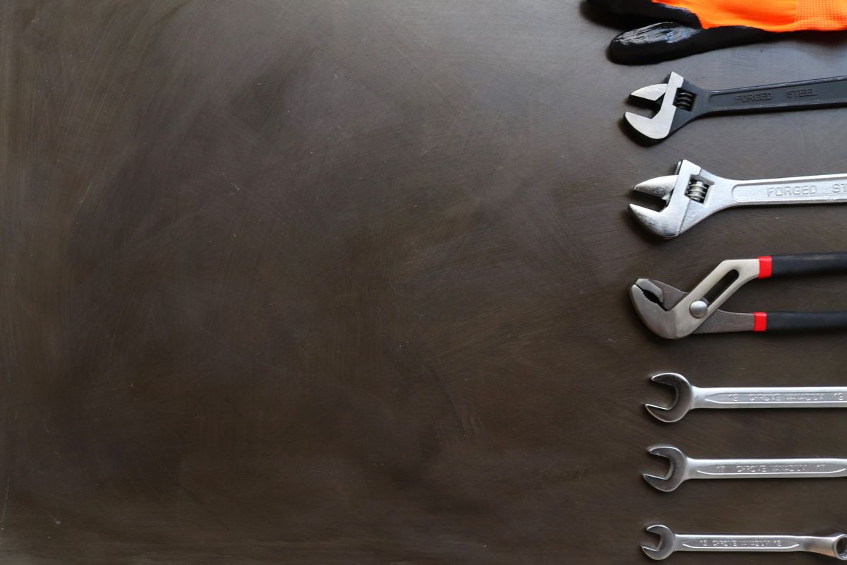 Set of plumbing wrenches of different sizes laid out on a work surface