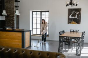 Professional cleaner mopping a tiled living room floor in a bright, tidy home