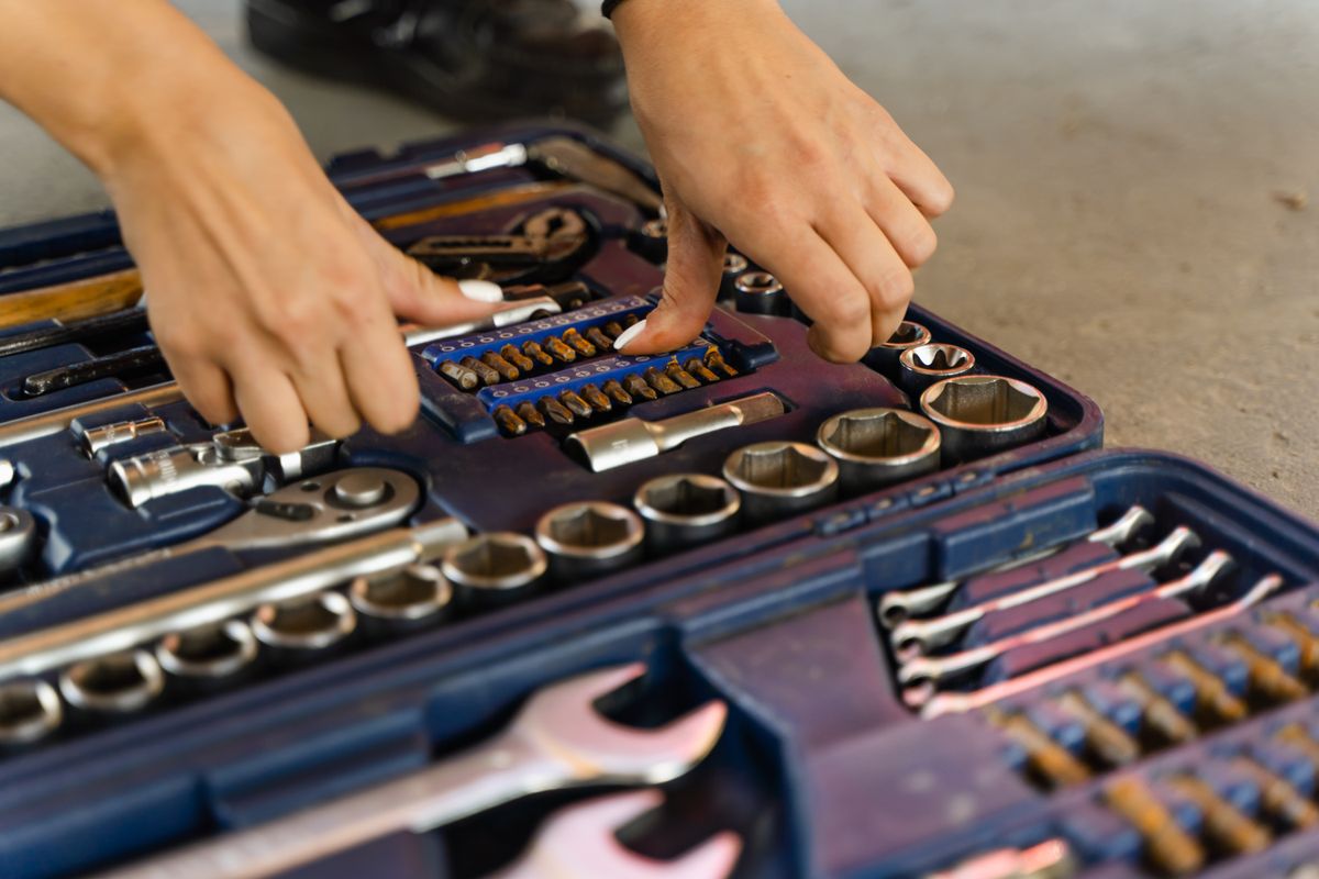 Tradesperson picking a tool out of an organised toolbox on a job