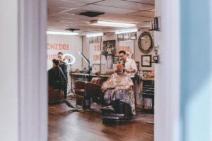 Barbers cutting clients' hair at chairs in a traditional barbershop