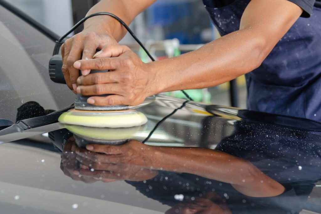 A detailer machine-buffing paintwork, the labour-intensive part of a full detail