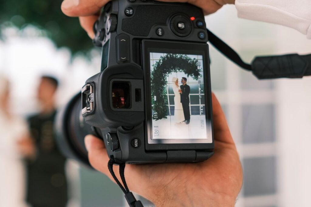 Camera viewfinder framing a bride and groom during wedding photography coverage