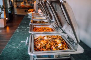A catered buffet held in heated food warmers to keep dishes out of the danger zone