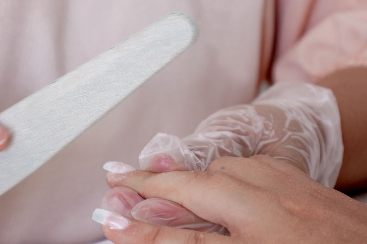 Close-up of a manicure in progress showing detailed nail care work
