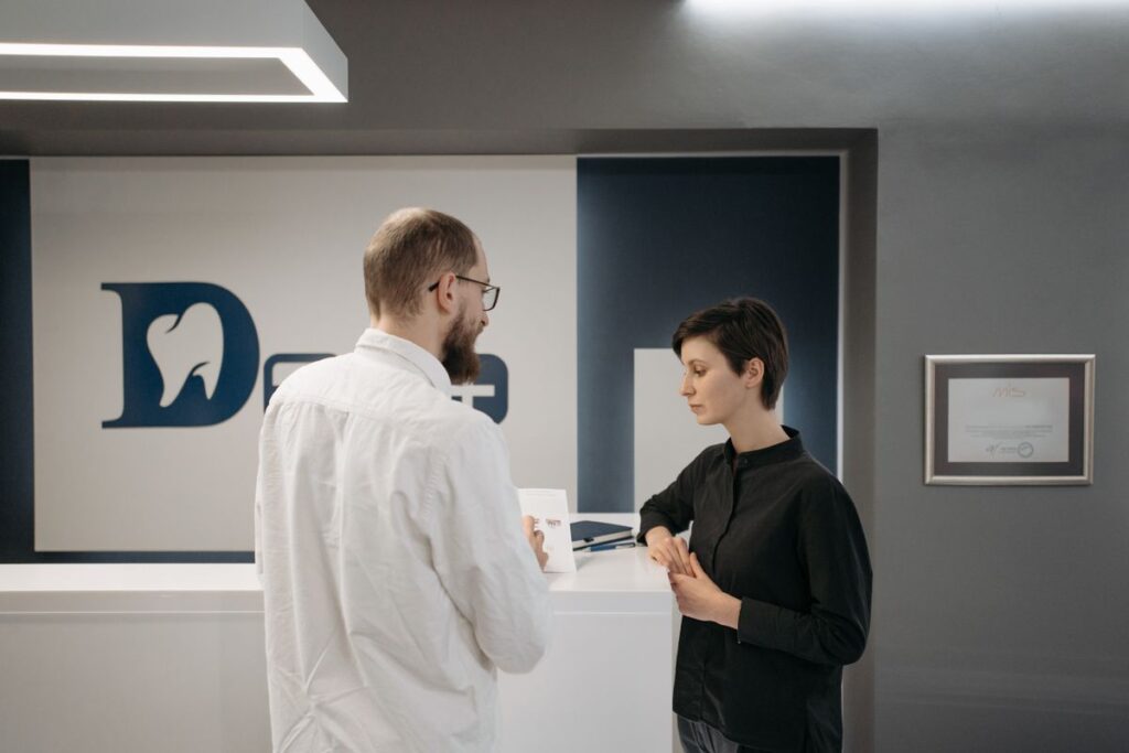 Dentist sitting and talking with a patient at a dental practice before treatment