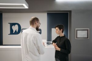 Dentist sitting and talking with a patient at a dental practice before treatment