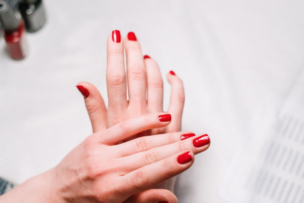 Finished manicure with glossy red polish photographed in a nail salon