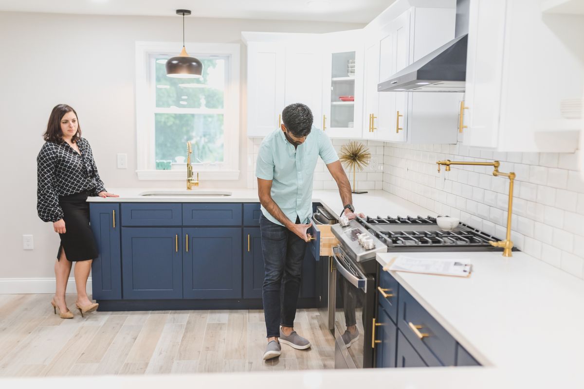Professional opening and inspecting a kitchen drawer during a home survey