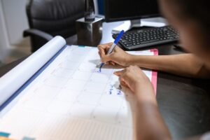 Marking dispute deadlines on a desk calendar while tracking credit repair progress