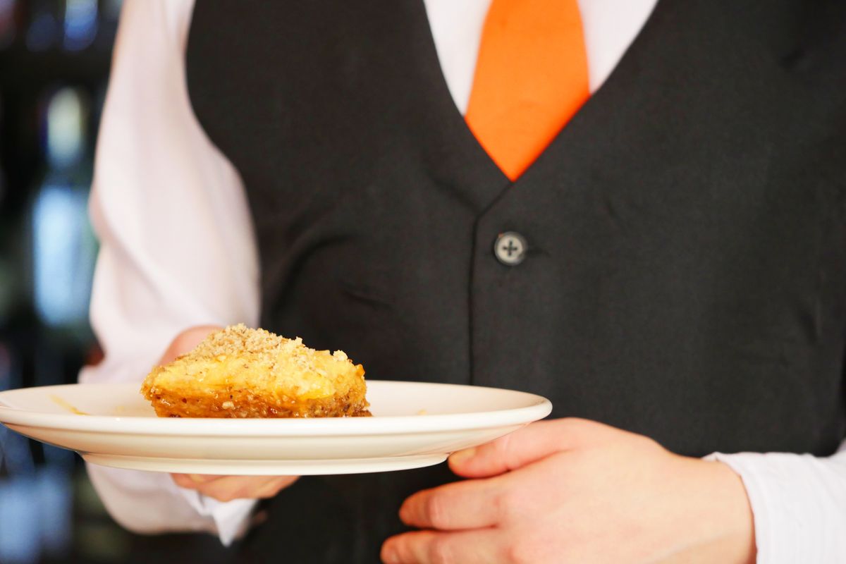 A server delivering a plated course, the most staff-intensive catering style