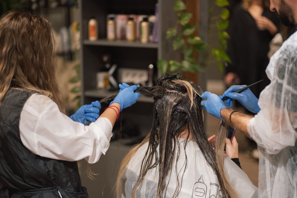 Stylists applying hair colour to a client in a modern hair salon