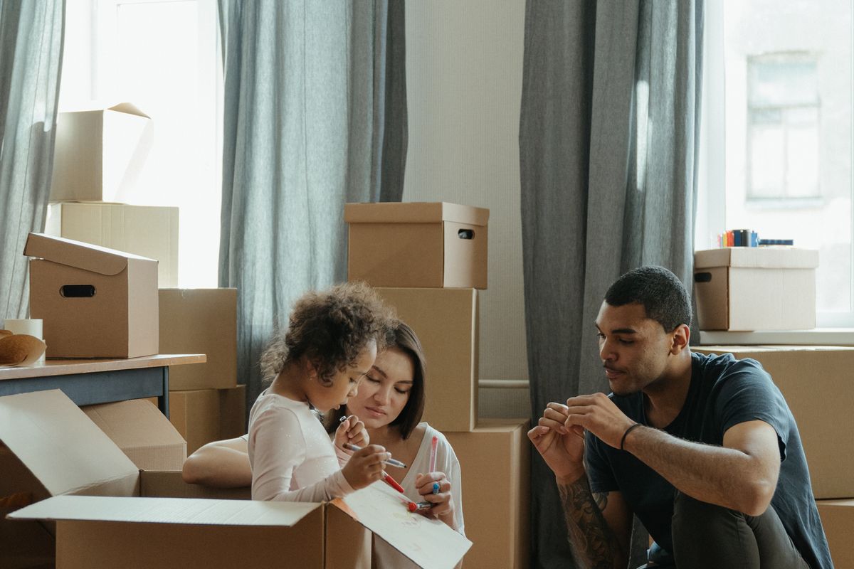 Couple sorting through cardboard boxes while unpacking in their new home