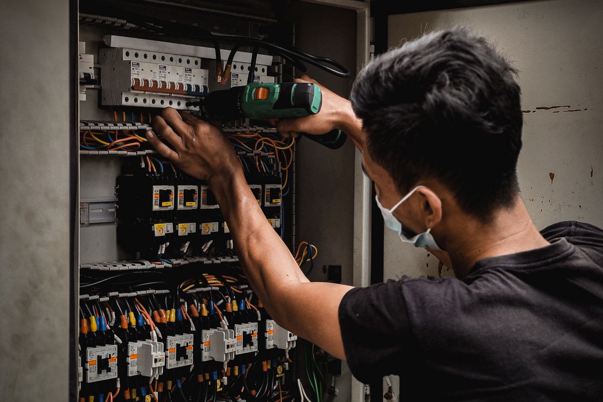 Technician adjusting wiring inside a residential circuit breaker panel
